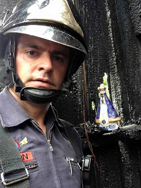 O bombeiro Anderson Batista junto à Imagem intocada pelo fogo em Dracena SP